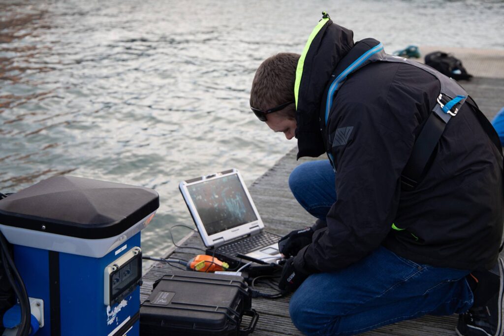 Scientist working on laptop at the marina